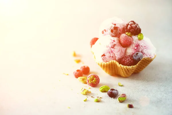 Rosafarbenes Eis mit Beeren, Erdbeeren, Blaubeeren, Himbeeren, Pistazien im Waffelkorb. Sommerfutterkonzept, Kopierraum. gesundes glutenfreies Fruchteis. Banner — Stockfoto