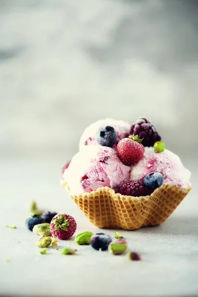 Rosafarbenes Eis mit Beeren, Erdbeeren, Blaubeeren, Himbeeren, Pistazien im Waffelkorb. Sommerfutterkonzept, Kopierraum. gesundes glutenfreies Fruchteis. Banner — Stockfoto