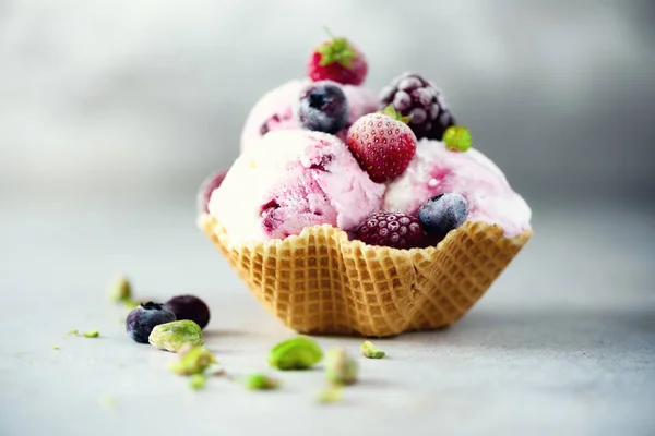 Rosafarbenes Eis mit Beeren, Erdbeeren, Blaubeeren, Himbeeren, Pistazien im Waffelkorb. Sommerfutterkonzept, Kopierraum. gesundes glutenfreies Fruchteis. Banner — Stockfoto