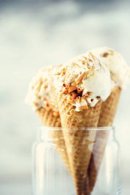 Karamel Sos dondurma waffle koni gri taş zemin üzerine kahve çekirdekleri ile. Yaz gıda kavramı, kopya alanı. Sağlıklı gluten ücretsiz dondurma. Afiş