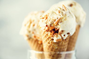 Karamel Sos dondurma waffle koni gri taş zemin üzerine kahve çekirdekleri ile. Yaz gıda kavramı, kopya alanı. Sağlıklı gluten ücretsiz dondurma. Afiş