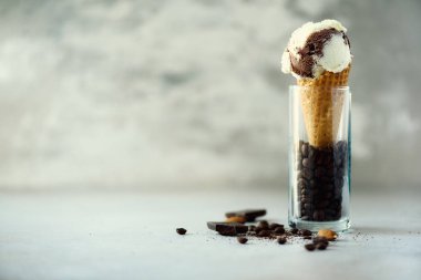 Çikolata, vanilya ve kahveli dondurma waffle koni gri taş zemin üzerine kahve çekirdekleri ile. Yaz gıda kavramı, kopya alanı. Sağlıklı gluten ücretsiz dondurma