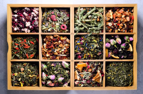 Assortment of dry tea in wooden box. Tea types: green, black, floral, herbal, mint, melissa, ginger, apple, rose, lime tree, fruits, orange, hibiscus, raspberry, cornflower, cranberry — Stock Photo, Image