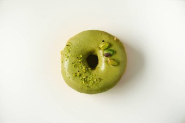 Tatlı çörek yeşil sır ve gri arka plan üzerine fıstık ile. Lezzetli çörek pastel beton doku, kopya alanı, üstten görünüm