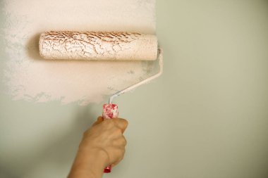 El boyama duvar boya silindiri, pastel renk ile. Daire tadilat, onarım, Bina ve ev kavramı. Kopya alanı, banner. Boya duvarlar için Araçlar.