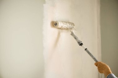 El boyama duvar boya silindiri, pastel renk ile. Daire tadilat, onarım, Bina ve ev kavramı. Kopya alanı, banner. Boya duvarlar için Araçlar.