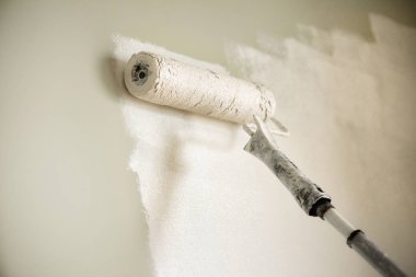 El boyama duvar boya silindiri, pastel renk ile. Daire tadilat, onarım, Bina ve ev kavramı. Kopya alanı, banner. Boya duvarlar için Araçlar.