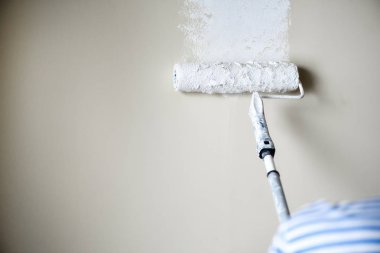 El boyama duvar boya silindiri, pastel renk ile. Daire tadilat, onarım, Bina ve ev kavramı. Kopya alanı, banner. Boya duvarlar için Araçlar.