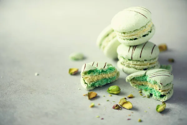 Menta verde macarrones franceses con pistachos. Pastel colores macarons, espacio de copia. Concepto de fiestas y celebraciones. Dulce regalo para mujer, niña — Foto de Stock