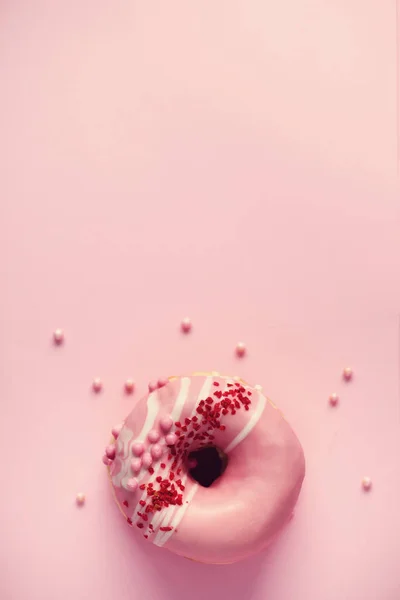 Söta ringdiagram med rosa glasyr på pastell bakgrund. Välsmakande donut på rosa konsistens, kopia utrymme, ovanifrån — Stockfoto