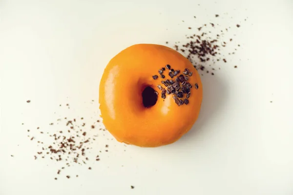 Doux beignet avec glaçure orange et chocolat sur fond gris. Donut savoureux sur texture de béton pastel, espace de copie, vue de dessus — Photo