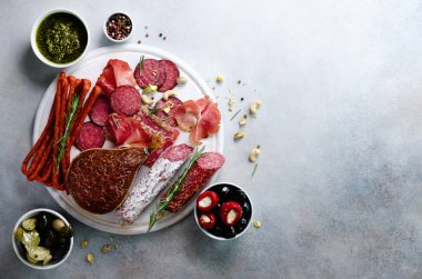 Soğuk füme et tabağı. Geleneksel İtalyan meze, gri arka plan üzerine kurulu salam, jambon, domuz, domuz eti, zeytin ile kesme. Görünümü ana sayfa, yer kopyalayın, yat