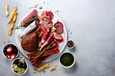 Soğuk füme et tabağı. Geleneksel İtalyan meze, gri arka plan üzerine kurulu salam, jambon, domuz, domuz eti, zeytin ile kesme. Görünümü ana sayfa, yer kopyalayın, yat