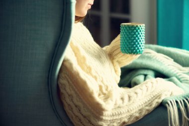 Limonlu çay fincan soğuk bir günde elinde yün kazaklı kadının el. Uzay kopyalayın. Kış ve yılbaşı tatil kavramı.