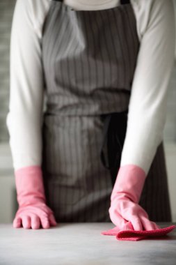 Koruyucu eldiven silerek toz ve kirli pembe kauçuk bir kadın. Temizleme kavramı, afiş, kopya alanı