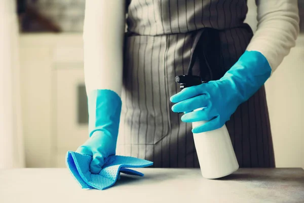 Wanita dalam sarung tangan pelindung karet biru membersihkan debu dan kotor. Membersihkan konsep, spanduk, menyalin ruang — Stok Foto