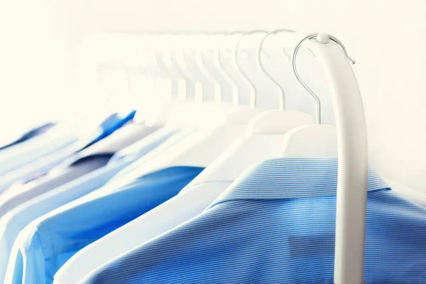 Blue color clothes. Male clothes, jackets and shirts hanging on clothes rail. Copy space. Banner — Stock Photo, Image