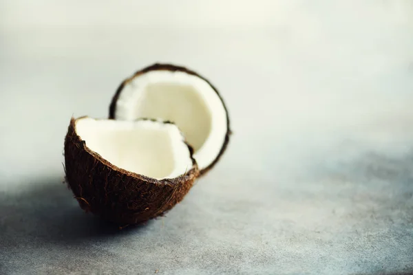 Knackte zwei Hälften frischer Bio-Kokosnuss auf grauem Hintergrund. Kopierraum — Stockfoto