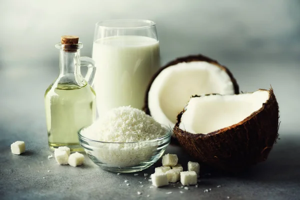 Produtos de coco - leite, óleo, aparas em fundo de concreto cinza. Espaço para cópia. Tratamento de cabelo, pele e corpo . — Fotografia de Stock