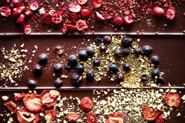 El yapımı çikolata ile kurutulmuş kızılcık, ahududu ve antep fıstığı, çilek, fındık. Karanlık ve sütlü çikolata karışımı, ürün yelpazesine sahip. Üstten Görünüm