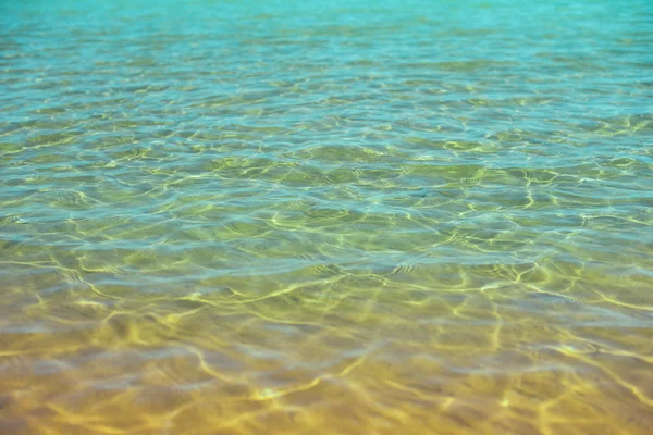 Água do mar e areia na praia do mar. Textura abstrata com espaço de cópia para o seu texto. Verão, férias e conceito de viagem — Fotografia de Stock