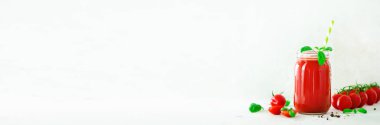Bir cam kavanoz, fesleğen, kiraz, tuz, biber ve saman ışık arka plan üzerinde organik taze domates suyu. Yemek temizlik ve kavram diyet. Uzay kopyalayın. Afiş