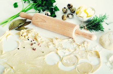 Geleneksel Rus mantı, mantı, mantı beyaz beton zemin üzerine etli. Maydanoz, bıldırcın yumurtası, biber, biberiye, defne yaprağı ve baharat. Üstten Görünüm. Kopya alanı