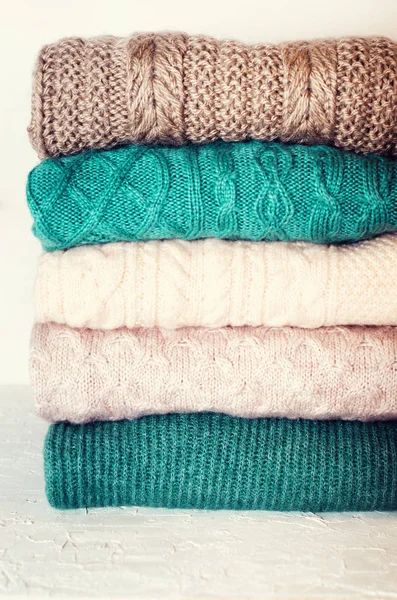 Pile of knitted wool sweaters on white background with copy space. Knitwear, clothes — Stock Photo, Image