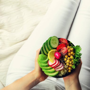 Kız eller vegan, avokado, quinoa, salatalık, turp, salata, limon, kiraz domates, nohut, chia tohum Tekstil arka plan üzerinde ile Detoks ham Buda kase tutar alanı kopyalayın, kırpma kare