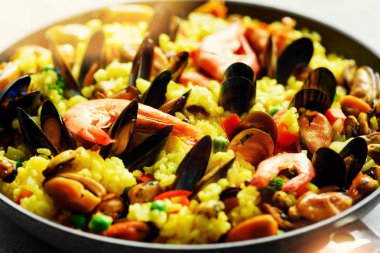 Geleneksel İspanyol deniz ürünleri paella pan pirinç, bezelye, karides, midye, mürekkep balığı ışık üzerinde beton arka plan gri. Üstten Görünüm boşaltmak. Kare kırpma