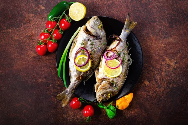 Μαγειρεμένα ψάρια ψημένα στη σχάρα, dorado, τσιπούρα με λεμόνι, βότανα, λαχανικά και μπαχαρικά σε φόντο ρουστίκ. Το Top view. Χώρο αντίγραφο — Φωτογραφία Αρχείου