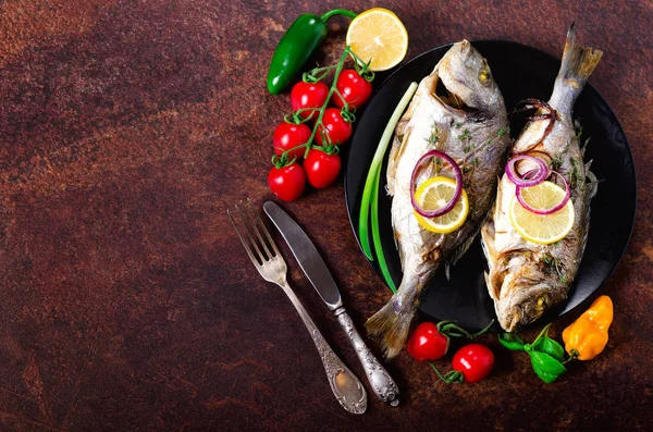 Peixe grelhado cozido no forno, dorado, dourado com limão, ervas, legumes e especiarias no fundo rústico. Vista superior. Espaço de cópia — Fotografia de Stock