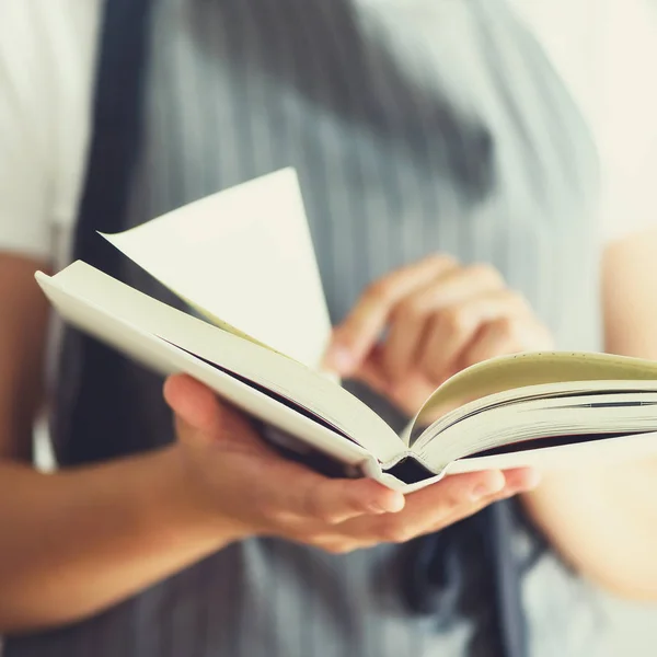 Menina vestindo avental cinza e livro de leitura. Conceito de estilo de vida. Culturas quadradas — Fotografia de Stock