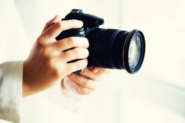 Holding fotoğraf makinesi, beyaz arka plan, kopya alanı kız eller. Seyahat ve ateş kavramı