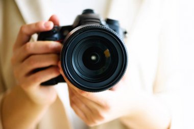 Holding fotoğraf makinesi, beyaz arka plan, kopya alanı kız eller. Seyahat ve ateş kavramı