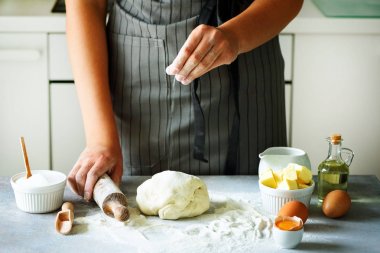 Erkek arka plan pişirme yoğurma hamur, eller. Malzemeler - yumurta, un, şeker, tereyağı, süt, oklava üzerinde beyaz mutfak pişirme. Kopya alanı