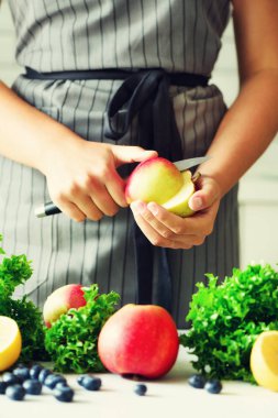 Kesme, elma yeşil smoothie için doğrama eller kadın. Ev yapımı sağlıklı yeşil güler yüzlü. Beyaz mutfak tasarımı