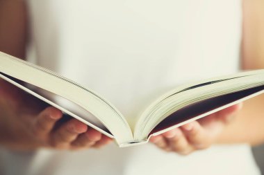 Genç kız beyaz T-shirt okuma kitabı açıldı. Uzay kopyalayın. yaşam tarzı ve okul kavramı