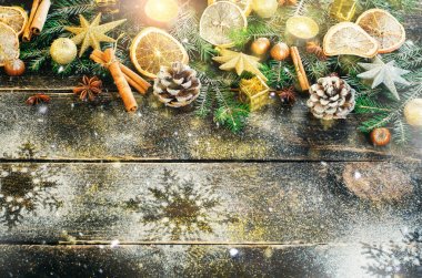 Noel tebrik kartı hediye, mum, koniler, tarçın sopa, eski koyu ahşap arka plan üzerinde kuru turuncu, yeşil ağaç. Üstten Görünüm sen metin için kopya yer ile. Kar ve bokeh