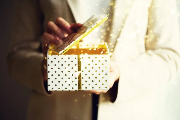 Des mains féminines tenant une boîte cadeau. Espace de copie. Noël, hew année, concept d'anniversaire. Fond festif avec bokeh et lumière du soleil. Conte de fées magique — Photo