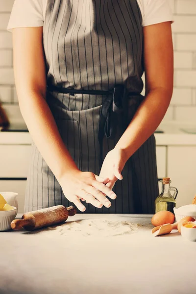 Manos femeninas amasando masa, horneando fondo. Cocinar los ingredientes - huevos, harina, azúcar, mantequilla, leche, rodillo en la cocina de estilo blanco. Copiar espacio — Foto de Stock