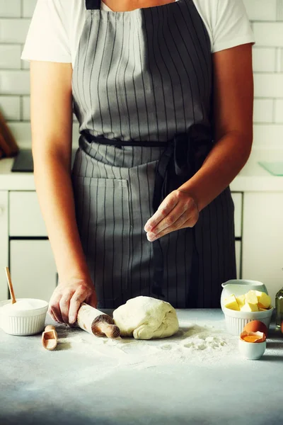 Manos femeninas amasando masa, horneando fondo. Cocinar los ingredientes - huevos, harina, azúcar, mantequilla, leche, rodillo en la cocina de estilo blanco. Copiar espacio — Foto de Stock