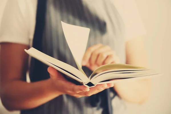 Menina vestindo avental cinza e livro de leitura. Conceito de estilo de vida — Fotografia de Stock