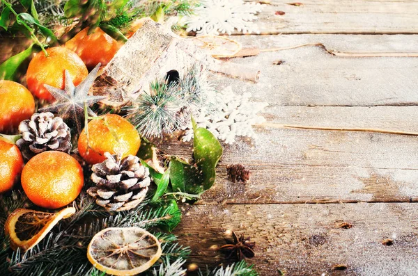 Magic Christmas background - vintage wood, candy cane, house, cinnamon, star anise, sweet mandarins with green leaves, cones, snowflakes. New Year. Top view, copy space, snow, bokeh. — Stock Image Magic Christmas background - vintage wood, candy cane, house, cinnamon, star anise, sweet mandarins with green leaves, cones, snowflakes. New Year. Top view, copy space, snow, bokeh. Stock Image