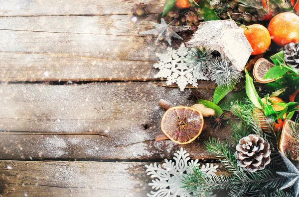 Magic Christmas background - vintage wood, candy cane, house, cinnamon, star anise, sweet mandarins with green leaves, cones, snowflakes. New Year. Top view, copy space, snow, bokeh. — Stock Photo, Image