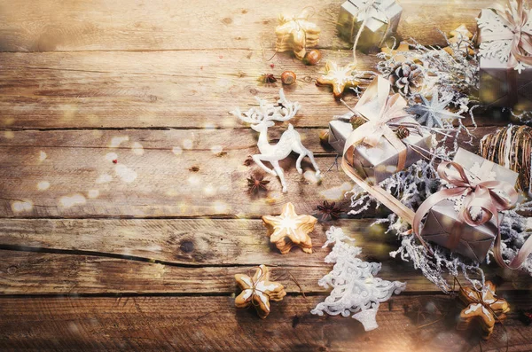 Corona de Navidad con galletas de jengibre, estrellas de plata, conos, avellanas, anís, cinta, cinta, copos de nieve, renos. Vista superior, espacio de copia, bokeh luz, efecto nieve, tonificado — Foto de Stock