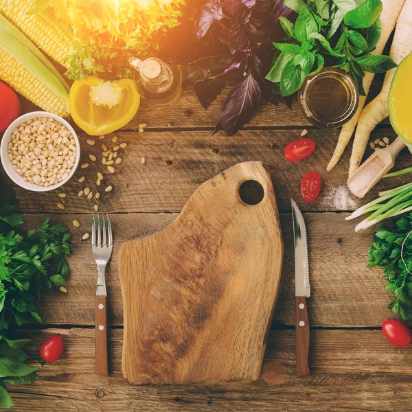 Woman hands cutting vegetables on wooden background. Vegetables cooking ingredients, top view, copy space, flat lay. Sunlight bokeh, toned pastel color, square — Stock Photo, Image