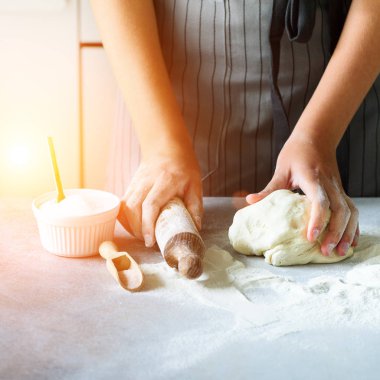 Erkek arka plan pişirme yoğurma hamur, eller. Malzemeler - yumurta, un, şeker, tereyağı, süt, oklava üzerinde beyaz mutfak pişirme. Kopya alanı