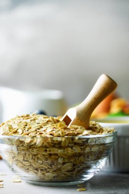 Yulaf ezmesi, yulaf gri beton zemin üzerine pul. Uzay kopyalayın. Sağlıklı kahvaltı konsepti.