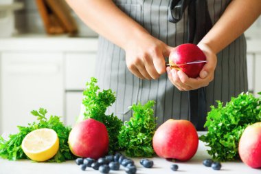 Kesme, elma yeşil smoothie için doğrama eller kadın. Ev yapımı sağlıklı yeşil güler yüzlü. Beyaz mutfak tasarımı